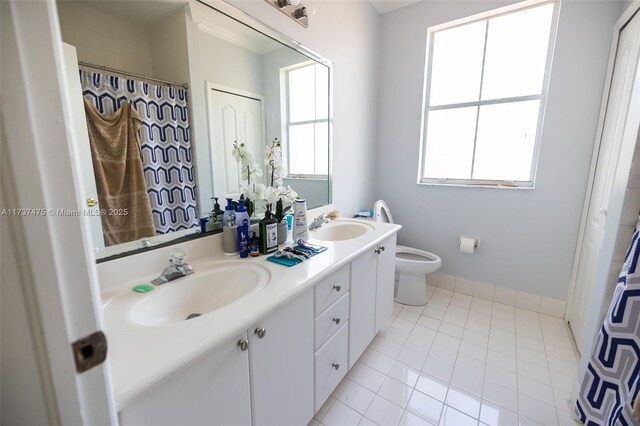 bathroom with vanity, a wealth of natural light, tile patterned floors, and toilet