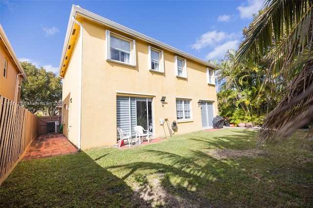 rear view of house featuring a yard and central AC unit