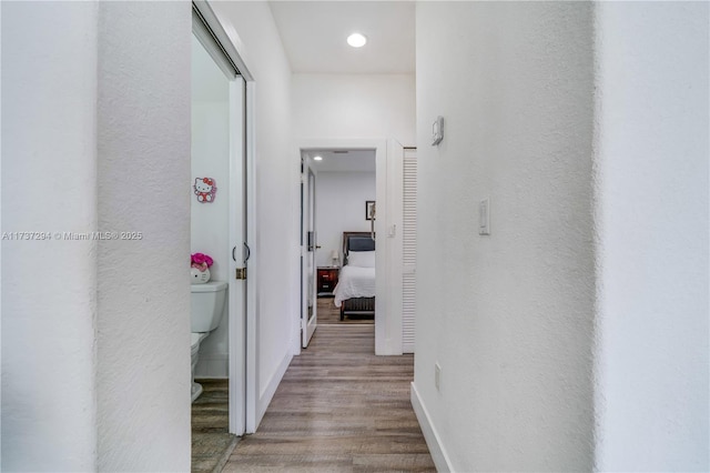 hallway with wood finished floors and baseboards