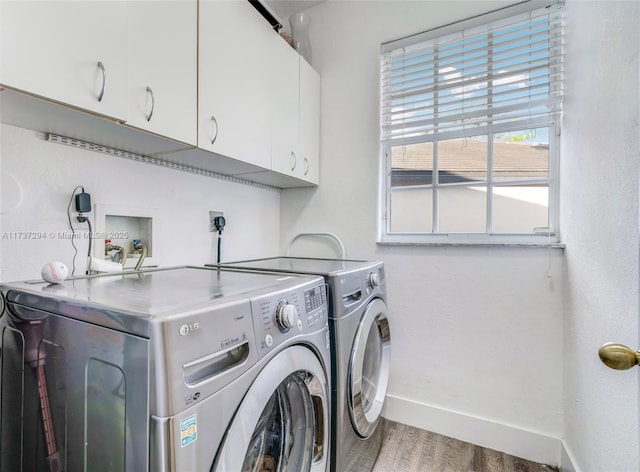 washroom featuring separate washer and dryer, hardwood / wood-style floors, and cabinets