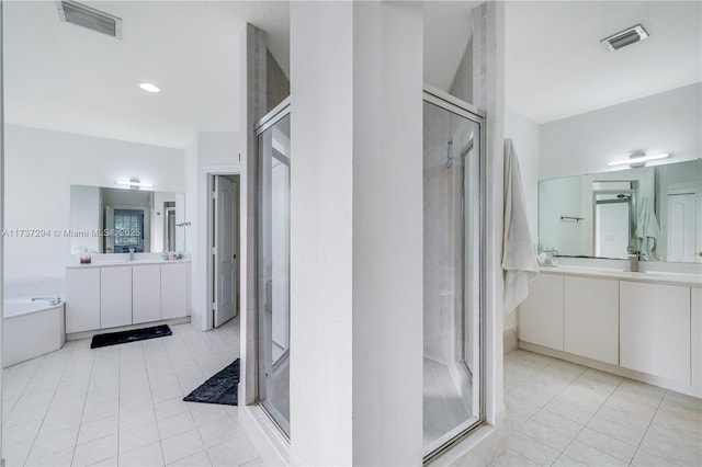 bathroom with tile patterned flooring, vanity, and shower with separate bathtub