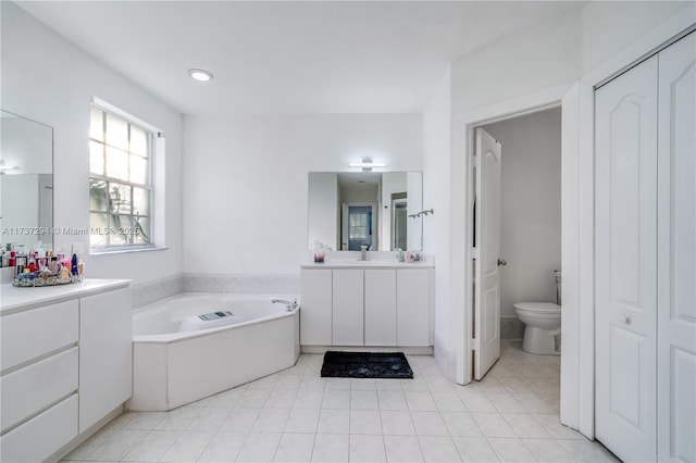 bathroom featuring vanity, toilet, tile patterned flooring, and a bathtub