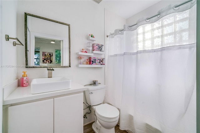 bathroom featuring curtained shower, vanity, and toilet