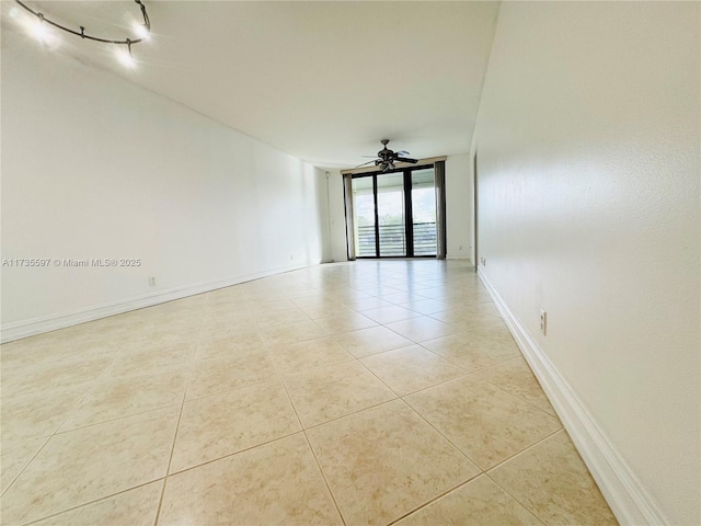 tiled empty room with expansive windows and ceiling fan