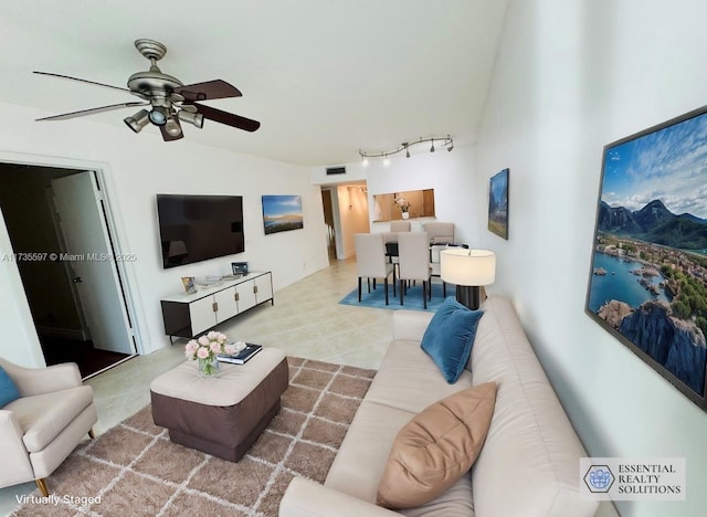 tiled living room featuring rail lighting, vaulted ceiling, and ceiling fan