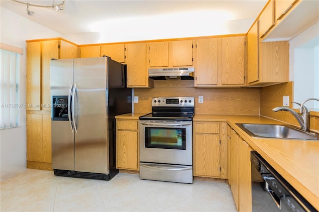 kitchen with light tile patterned flooring, stainless steel appliances, sink, and tasteful backsplash