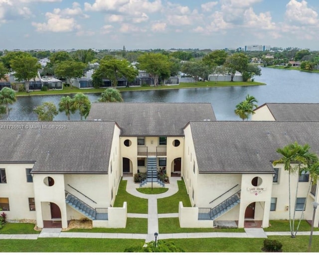 11312 Taft St Unit 11312, Pembroke Pines, FL 33026 - view of front facade with stairway, a shingled roof, a water view, and stucco siding