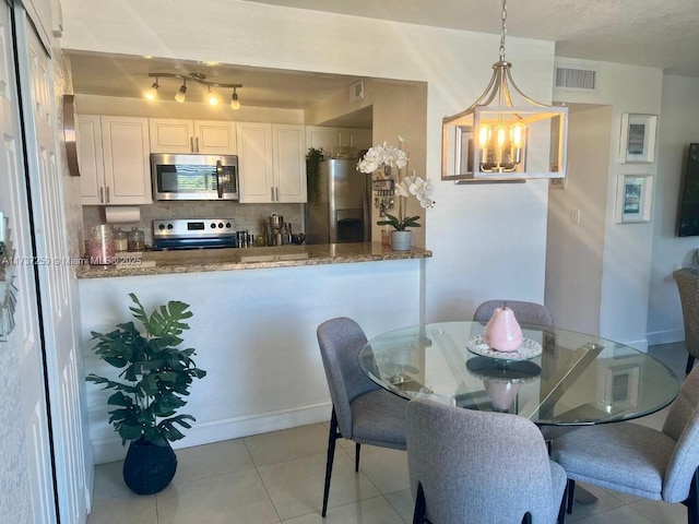 tiled dining room featuring an inviting chandelier