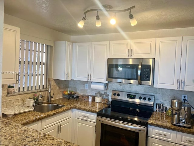 kitchen featuring white cabinetry, appliances with stainless steel finishes, and backsplash