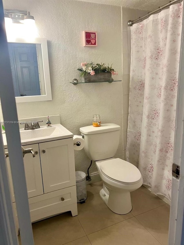 bathroom featuring vanity, curtained shower, tile patterned floors, and toilet