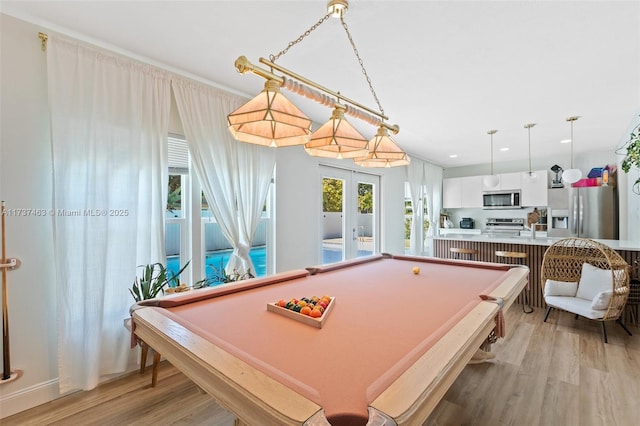 rec room with french doors, pool table, and light hardwood / wood-style floors