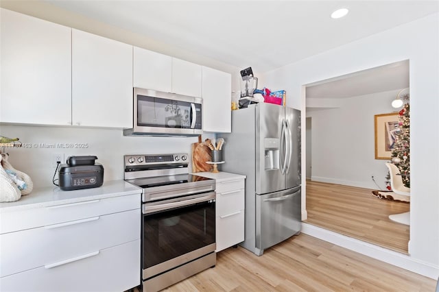 kitchen featuring white cabinetry, light hardwood / wood-style flooring, and appliances with stainless steel finishes