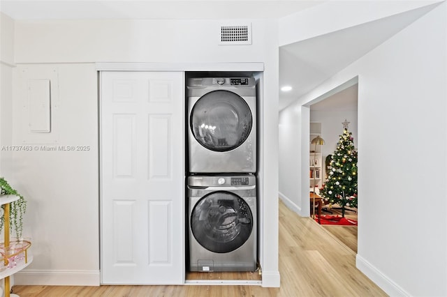 clothes washing area with stacked washer / drying machine and hardwood / wood-style floors