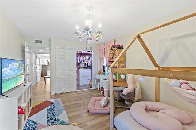 bedroom featuring a notable chandelier, light hardwood / wood-style flooring, and a closet