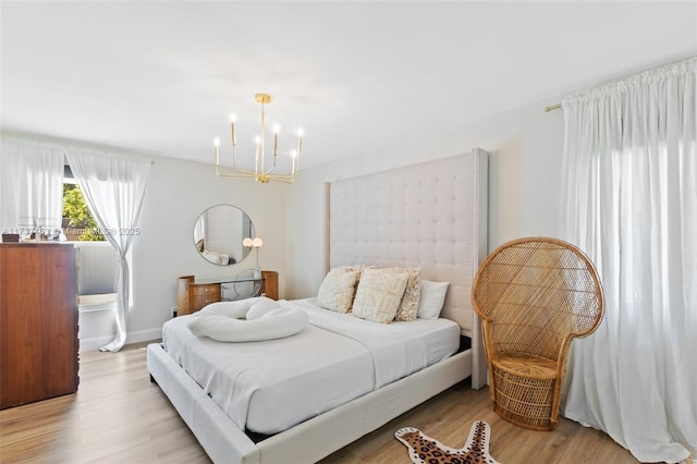 bedroom with a notable chandelier and light hardwood / wood-style flooring