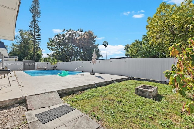 view of swimming pool with an outdoor fire pit, a patio, and a lawn