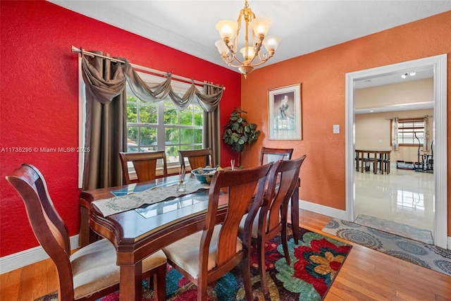 dining area with a notable chandelier, hardwood / wood-style floors, and a wealth of natural light