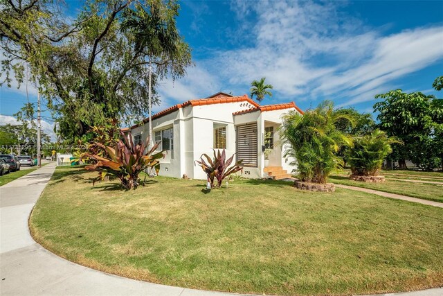 2039 SW 17th St, Miami, FL 33145 - view of property exterior with a tile roof, stucco siding, and a yard