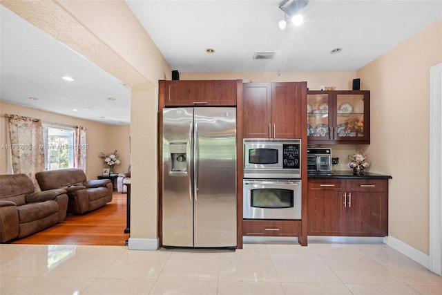 2039 SW 17th St, Miami, FL 33145 - kitchen with light tile patterned floors, stainless steel appliances, glass insert cabinets, and visible vents