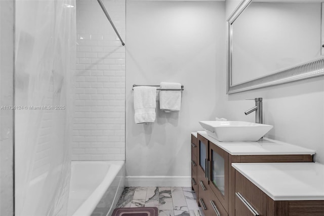 bathroom featuring tiled shower / bath and vanity