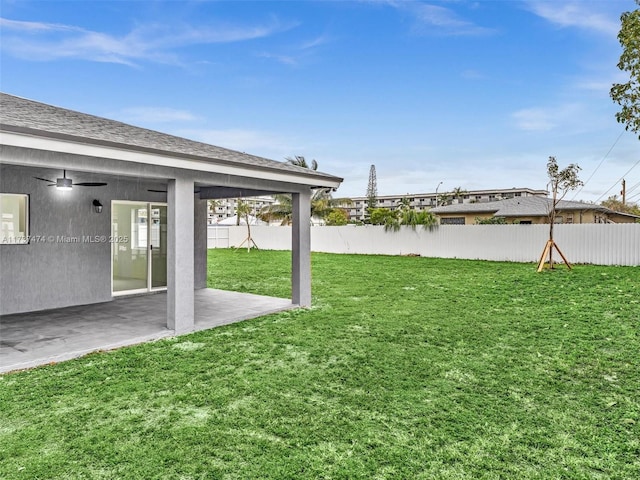 view of yard featuring fence, a ceiling fan, and a patio