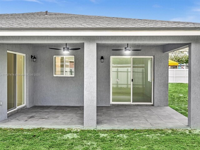 property entrance with stucco siding, a patio area, and ceiling fan