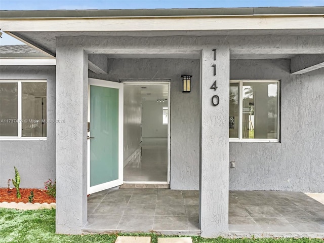 view of exterior entry with stucco siding