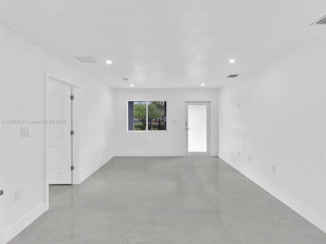 empty room with recessed lighting, visible vents, and baseboards