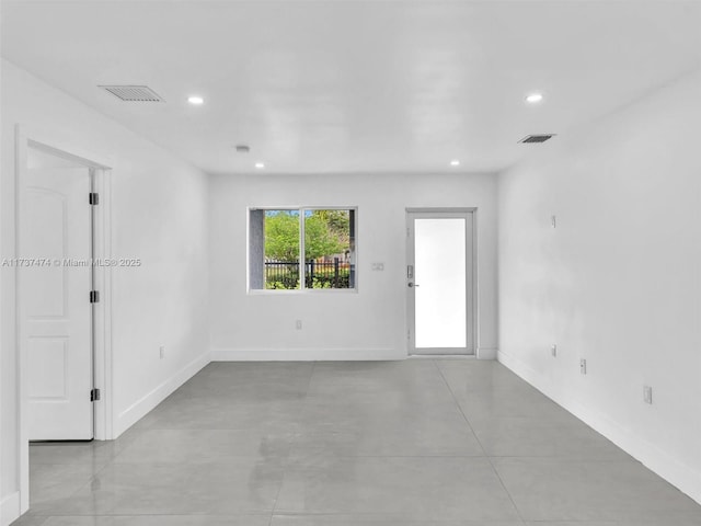 empty room featuring baseboards, visible vents, and recessed lighting