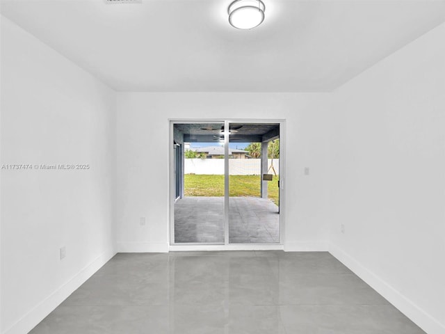 unfurnished room with baseboards and finished concrete flooring
