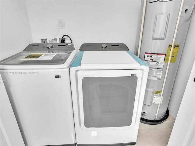 laundry room featuring water heater, washing machine and clothes dryer, and laundry area