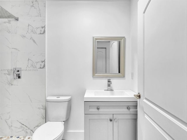 bathroom featuring toilet, vanity, and a tile shower