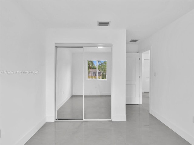 unfurnished bedroom featuring baseboards, visible vents, and a closet