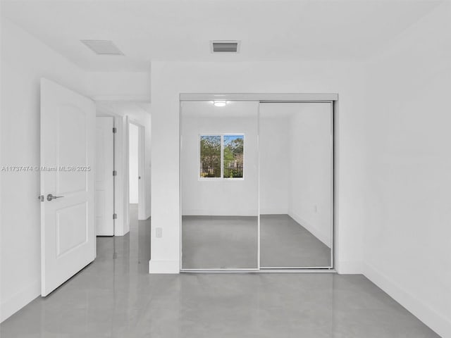 unfurnished bedroom featuring a closet, visible vents, baseboards, and finished concrete floors