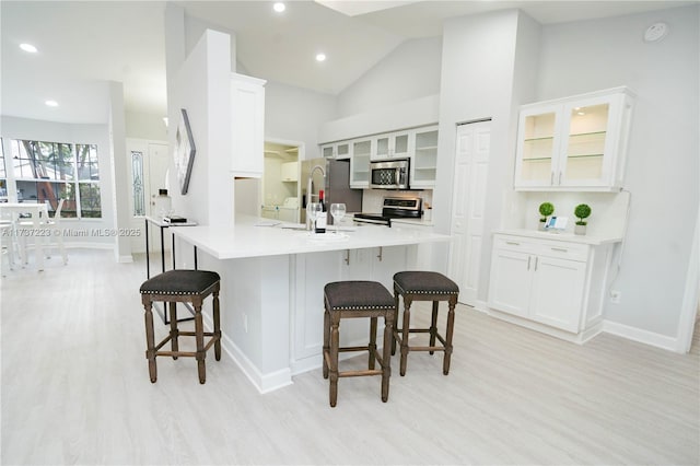 kitchen with white cabinetry, a kitchen bar, and appliances with stainless steel finishes