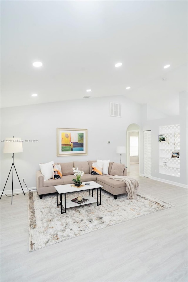 living room featuring vaulted ceiling and light wood-type flooring