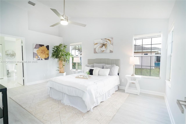 bedroom featuring ceiling fan, high vaulted ceiling, connected bathroom, and light hardwood / wood-style floors