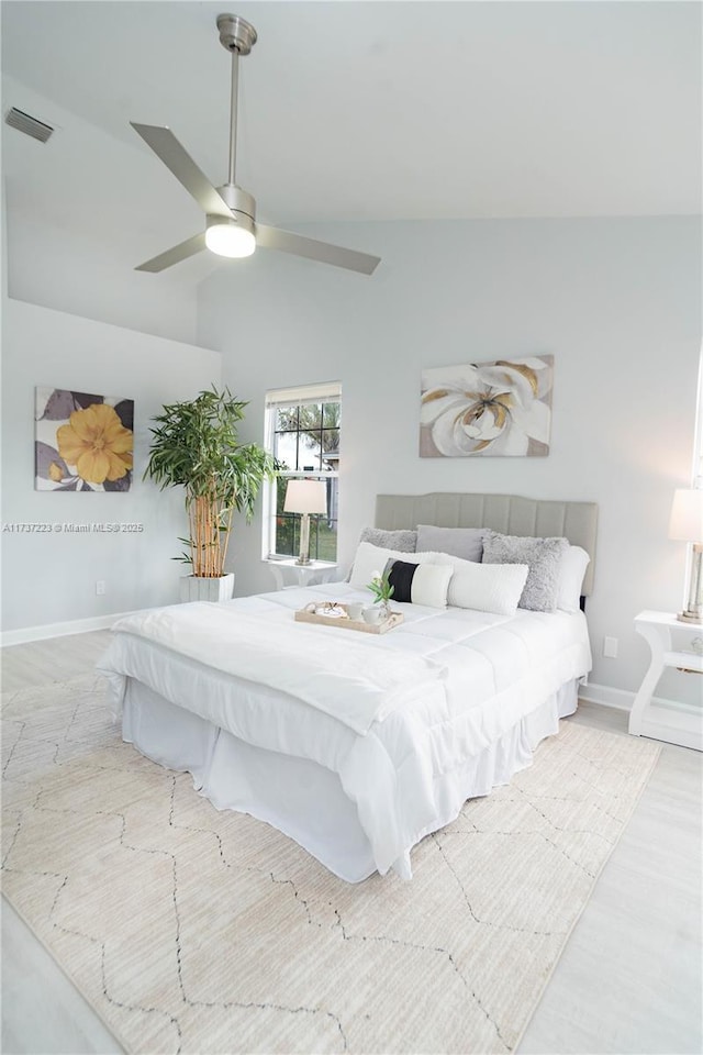 bedroom featuring ceiling fan, lofted ceiling, and light wood-type flooring