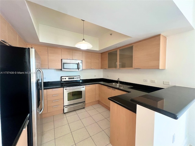 kitchen with kitchen peninsula, sink, light tile patterned floors, a tray ceiling, and stainless steel appliances