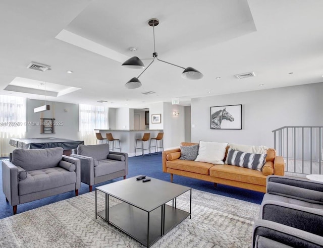 carpeted living room with a raised ceiling