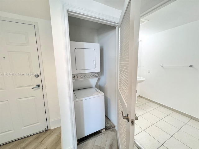 clothes washing area featuring stacked washer / drying machine and light wood-type flooring