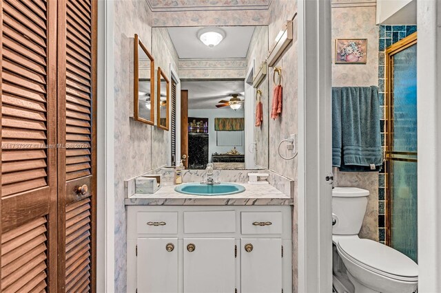 bathroom featuring vanity, walk in shower, ceiling fan, and toilet