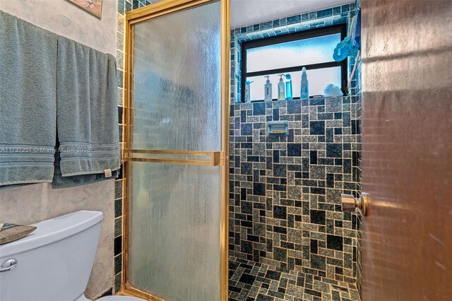 bathroom featuring an enclosed shower and toilet