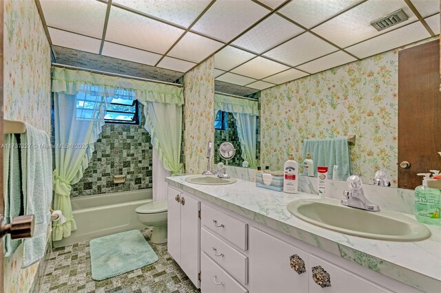 full bathroom featuring vanity, a drop ceiling, shower / bath combination with curtain, and toilet