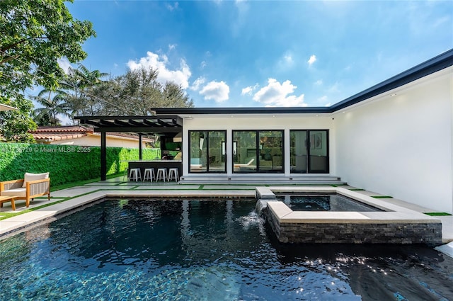 view of swimming pool with a patio, an outdoor bar, and an in ground hot tub