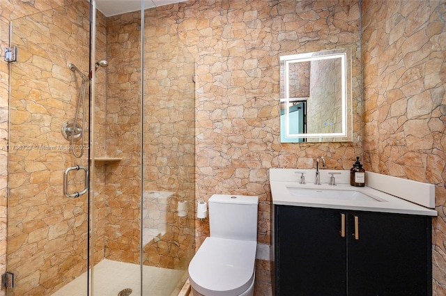 bathroom featuring vanity, toilet, and a shower with door