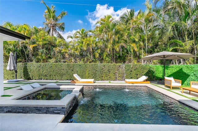 view of pool featuring pool water feature and an in ground hot tub