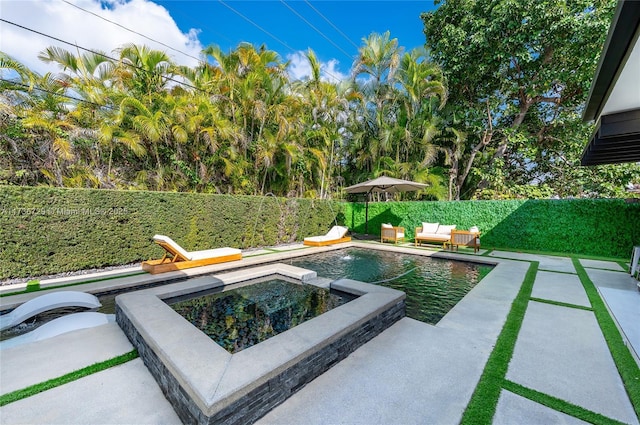 view of swimming pool featuring an in ground hot tub and a patio