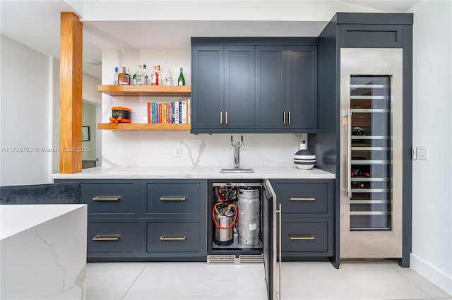 bar with wine cooler, sink, tasteful backsplash, light tile patterned floors, and light stone countertops