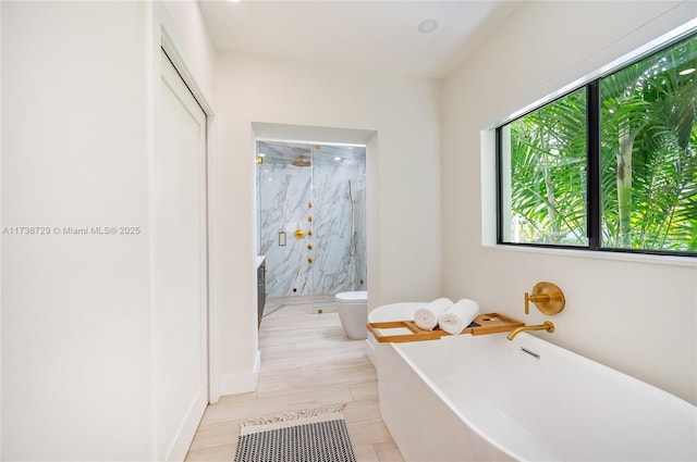 bathroom with shower with separate bathtub and toilet